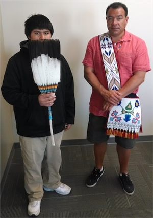 Modern individuals holding Native American artifacts